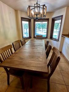 uma sala de jantar com uma grande mesa de madeira e cadeiras em Beautiful Farm Home near NMSU em Las Cruces