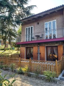 a house with a wooden fence in front of it at B&B Borgo dei Cedri in Pontecchio