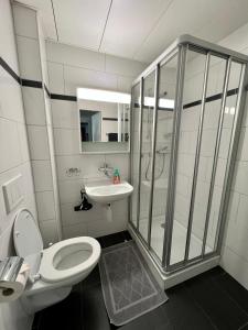 a bathroom with a shower and a toilet and a sink at Seefeld Residenz in Zürich