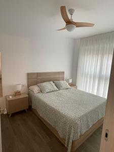 1 dormitorio con 1 cama y ventilador de techo en Lovely Beach Apartment en Rincón de la Victoria
