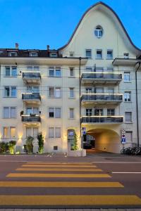 um grande edifício branco com uma faixa de pedestres em frente em Seefeld Residenz em Zurique