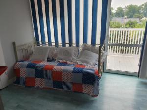 a bedroom with a bed with a striped curtain at Agroturystyka santa monica in Morzyczyn