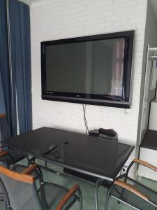 a flat screen tv hanging on a wall with a table at Agroturystyka santa monica in Morzyczyn