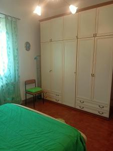 a bedroom with white cabinets and a chair and a bed at Nonna Lella House in Castel di Sangro