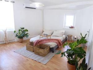 ein Wohnzimmer mit einem Bett in einem Zimmer mit Pflanzen in der Unterkunft La Maison du Château au calme et centrale in Tournon-sur-Rhône