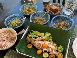 a table with a plate of food and bowls of food at Suwetha villa Ayurveda Resort in Bentota