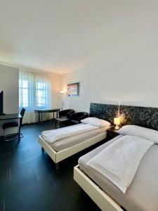 um quarto de hotel com duas camas e uma secretária em Seefeld Residenz em Zürich