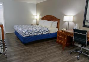 a hotel room with a bed and a desk and a chair at America's Best Value Inn Lancaster in Lancaster