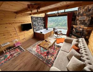 a living room with a couch and a tub at Moni Suit Bungalov in Rize