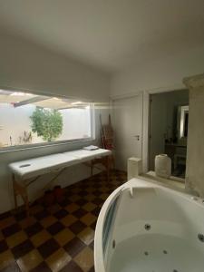a bathroom with a bath tub and a window at Casa Monte Tamissa in Vila Real de Santo António
