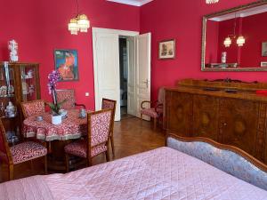 a bedroom with a table and a red wall at Retro big Apartment with two balconies and lift in Karlovy Vary