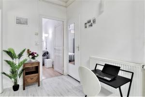a white room with a desk with a laptop on it at Tarbes Immeuble résidentiel labelisé et classé Proche des Halles Marcadieu et Brauhauban et du Parc des expositions - Appartements Appaloosa T2 Rdc et Pyrénéa T2 au 1er étage avec terrasse couverte -Parking gratuit- in Tarbes