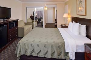 a hotel room with a large bed and a living room at Quality Inn & Suites Montebello - Los Angeles in Montebello