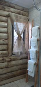 una ventana en una cabaña de madera con una cortina en Ventanas al Norte en Chascomús