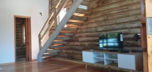 a room with a wooden wall with a tv and a staircase at Ventanas al Norte in Chascomús