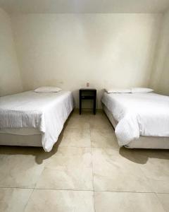 - deux lits assis l'un à côté de l'autre dans une pièce dans l'établissement Galería Concordia, à Antiguo Tamuín