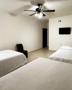 a bedroom with two beds and a ceiling fan at Galería Concordia in Antiguo Tamuín