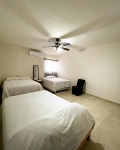 1 dormitorio con 2 camas y ventilador de techo en Galería Concordia en Antiguo Tamuín