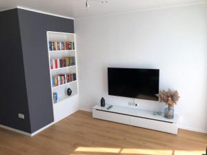 a living room with a flat screen tv on a white wall at Apartment-Regner in Weidenberg