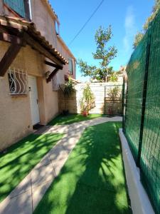 a yard with a fence and green grass at Maison de vacances Marseille in Marseille