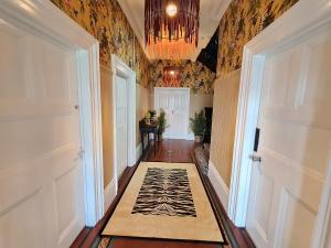 een hal met een tapijt op de vloer en een kroonluchter bij Birdy Room - Lemur Lodge in Bournemouth