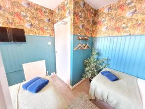 een slaapkamer met 2 bedden en kleurrijk behang bij Birdy Room - Lemur Lodge in Bournemouth
