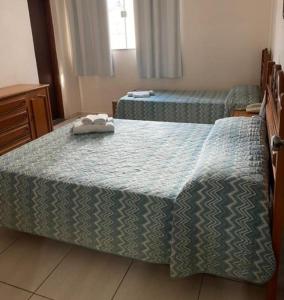 Dos camas en una habitación de hotel con toallas. en Hotel Regência, en São Lourenço