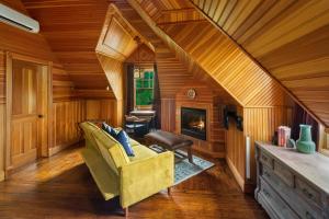 a living room with a yellow couch and a fireplace at Hotel Mountain Brook in Tannersville