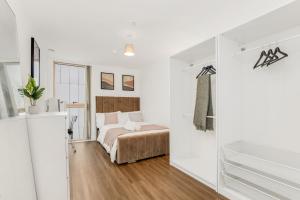 a bedroom with a bed in a white room at Khayat Homes - The Luxx - One Bed in London