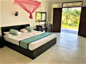 a bedroom with a large bed in a room at Ayurveda Suwetha Villa in Bentota