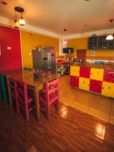 Il comprend une cuisine équipée d'une table en bois et d'un réfrigérateur. dans l'établissement The Chusay Rooftop, à Cusco