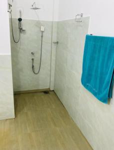 baño con ducha y toalla azul en la pared en Ayurveda Suwetha Villa, en Bentota