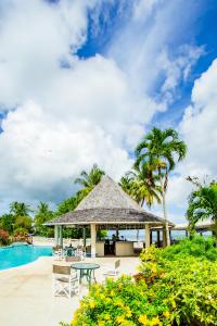 un pabellón con mesa y sillas junto a una piscina en Starfish Tobago, en Scarborough