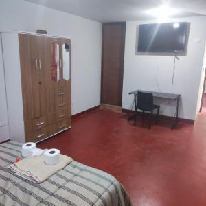 - une chambre avec un lit, un bureau et une télévision dans l'établissement HOSPEDAJE MILAGRITOS, à Chachapoyas