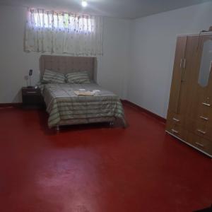 Schlafzimmer mit einem Bett und einem roten Teppich in der Unterkunft HOSPEDAJE MILAGRITOS in Chachapoyas