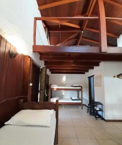 a bedroom with a bed and a wooden ceiling at Pousada das Palmeiras in Garopaba
