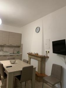 uma cozinha com mesa e cadeiras e um relógio na parede em Iezza Residence em San Polo Matese