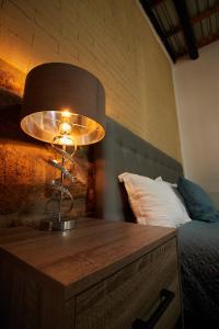 um candeeiro numa mesa de madeira ao lado de uma cama em Hotel Casa Ceci Inn em San José del Cabo