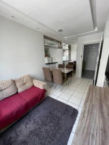 - un salon avec un canapé rouge et une table dans l'établissement Apartamento próximo ao aeroporto, à Fortaleza