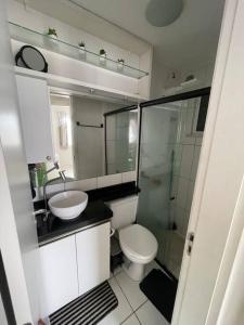 La salle de bains est pourvue de toilettes, d'un lavabo et d'une douche. dans l'établissement Apartamento próximo ao aeroporto, à Fortaleza