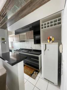 Il comprend une cuisine équipée d'une cuisinière et d'un réfrigérateur. dans l'établissement Apartamento próximo ao aeroporto, à Fortaleza