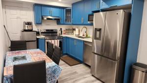 紐馬克特的住宿－2 Bedrooms 2 washrooms 2 parking spots Basement Apartment，厨房配有蓝色橱柜、桌子和冰箱。