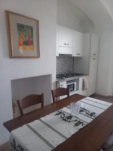 a kitchen with a dining table and a kitchen with a stove at I Due Camini in Baraggia di Boca