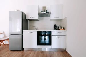 una cocina con armarios blancos y horno negro en PRIMO RENT ROOM, en Mesagne