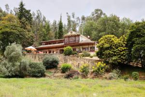 a large house on top of a stone wall at Posada el portal de la Loma in Pesca