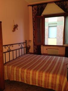 Schlafzimmer mit einem Bett und einem Fenster in der Unterkunft Stanza Bellaria in Pontedera