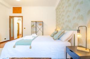 um quarto com uma grande cama branca e uma secretária em La Casa di Azzurra em Roma
