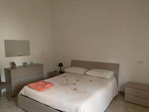 um quarto com uma cama com lençóis brancos e um espelho em Iezza Residence em San Polo Matese