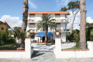 a building with palm trees in front of it at Hotel La Palma in Lido di Camaiore