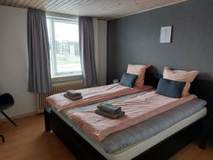 a large bed in a room with a window at Venos rooms in Hirtshals